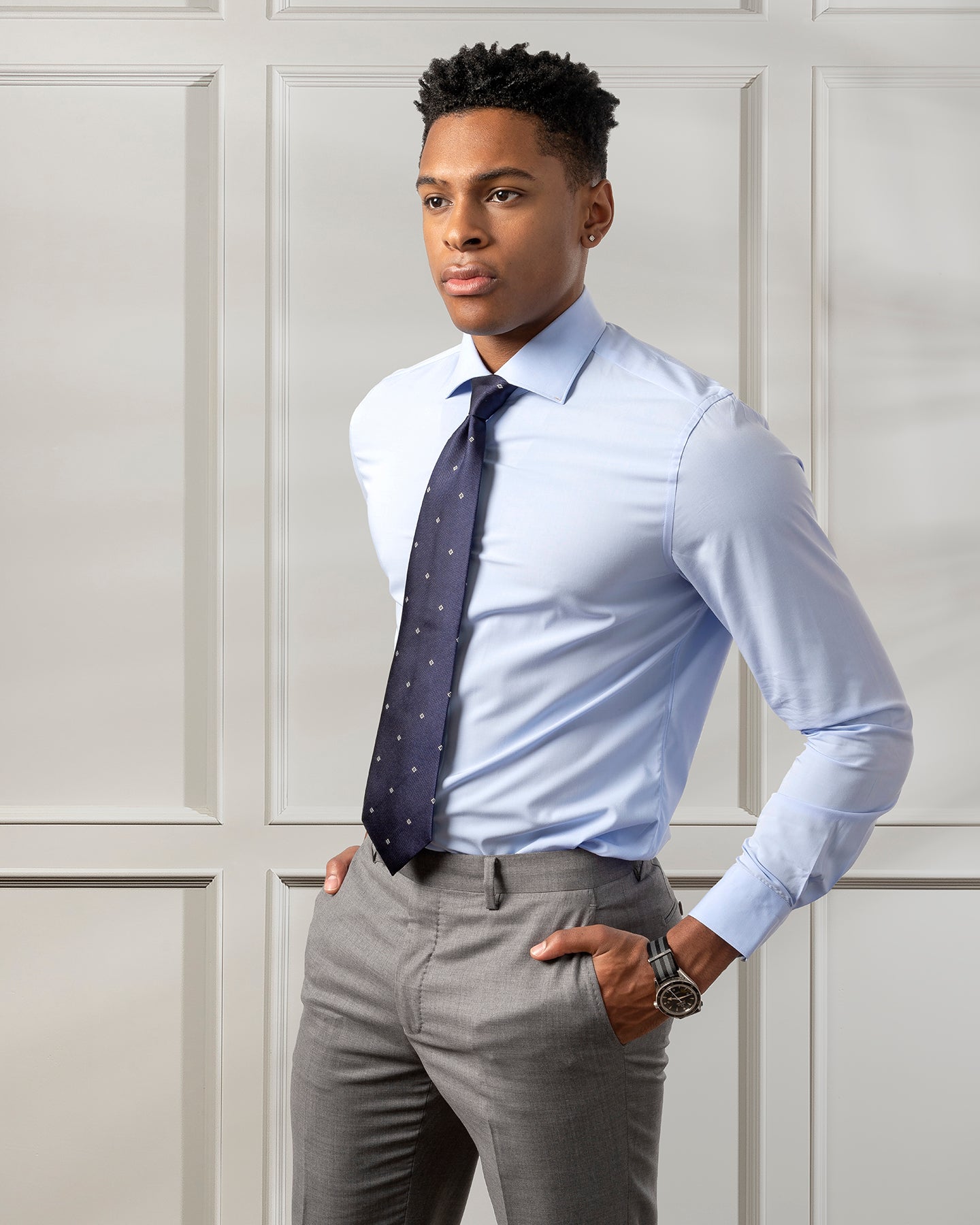 Dressing in a light blue shirt, a colorful pattern tie, gray pants, a young  black businessman is smiling, sitting outside to make a phone call on his  Stock Photo - Alamy